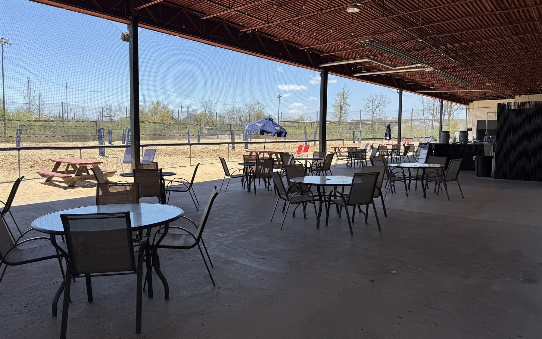 Covered patio seating beside the sand volleyball courts at On The Dunes Sports